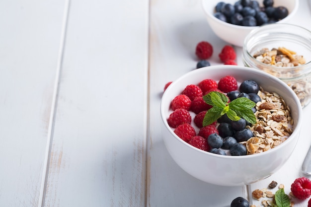 Tazón de batido con yogur, bayas frescas y cereales. Ingredientes crudos para un buen día