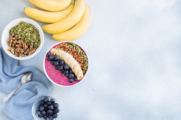 Tazón de batidos de acai con arándanos, plátano, nueces, semillas de calabaza y sésamo