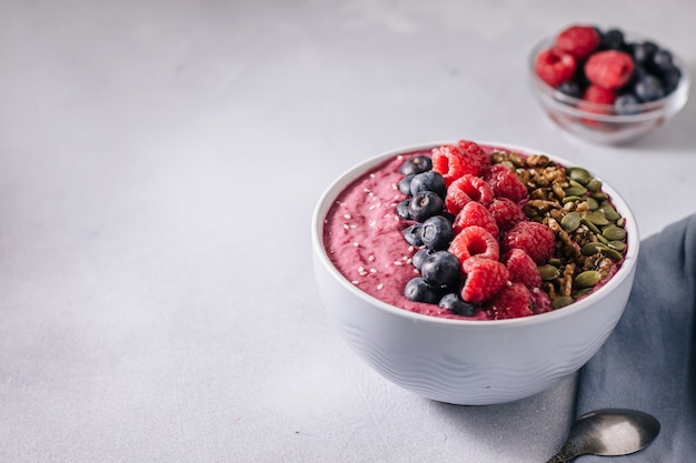 Tazón de batidos de acai con bayas, nueces, semillas de calabaza y sésamo