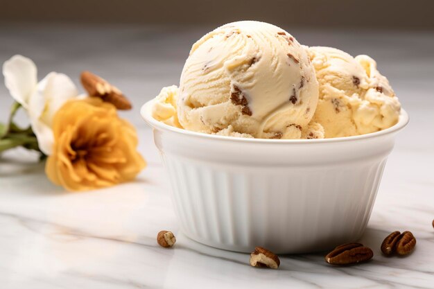 Un tazón blanco de helado de nueces de mantequilla en una encimera de mármol