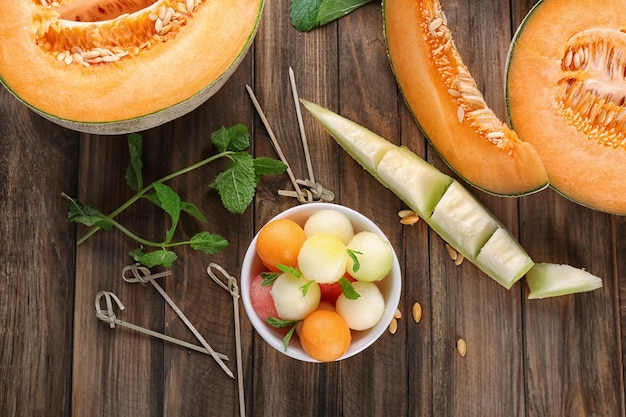 Foto tazón con bolas de fruta fresca en la mesa