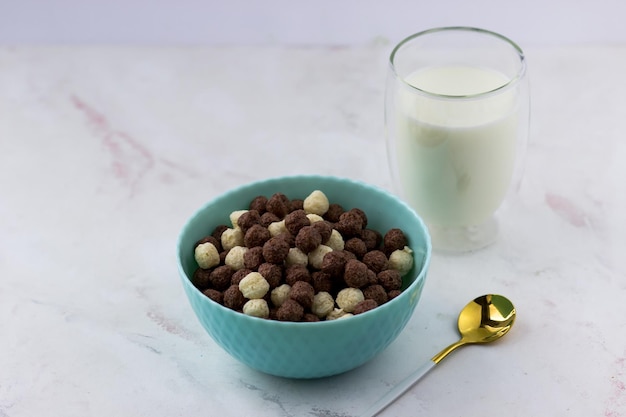 Tazón con bolas de vainilla y chocolate sobre un fondo blanco Aperitivos y un vaso de leche desayuno rápido