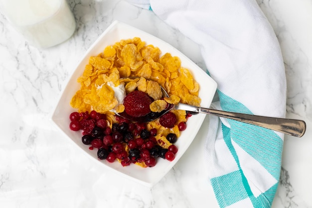 tazón de cereal con leche de bayas y yogur sobre fondo blanco