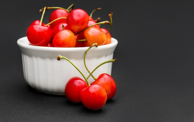 Tazón con cerezas sobre fondo negro