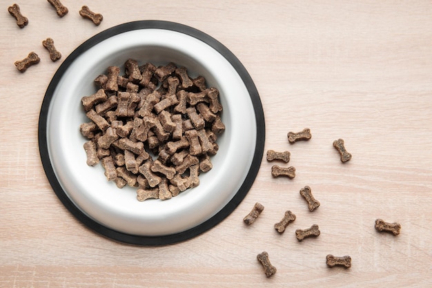 Un tazón de comida para perros en un piso de madera