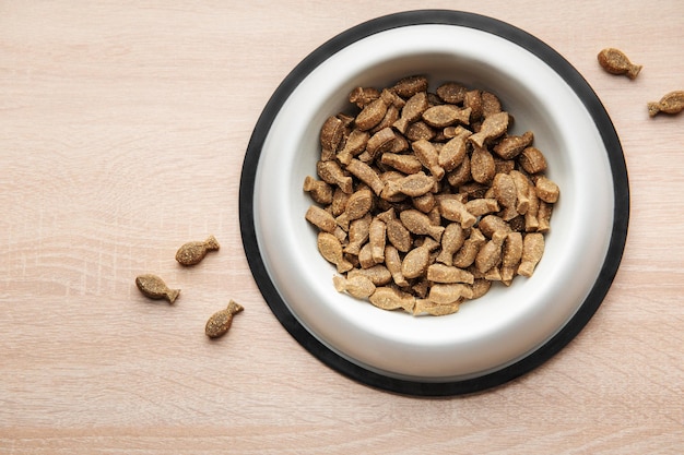 Un tazón de comida para perros en un piso de madera