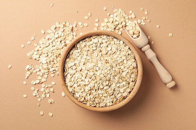 Tazón y cuchara con copos de avena en la pared de artesanía