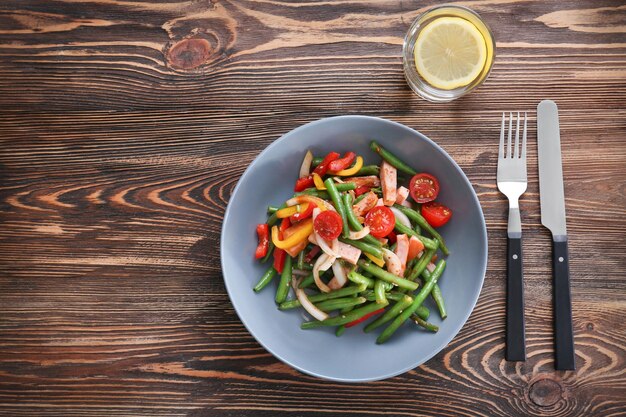 Tazón con deliciosa ensalada de judías verdes en la mesa de madera