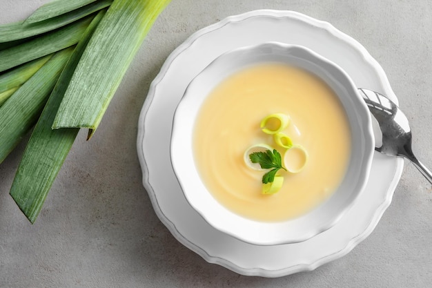 Tazón de deliciosa sopa de patata con puerro en la mesa