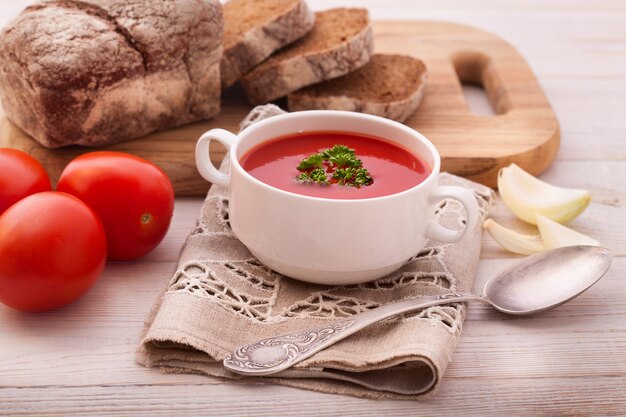 Tazón de deliciosa sopa de puré de verduras y pan en la mesa de madera