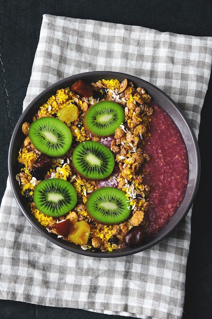 Tazón de desayuno con batido de acai, avena, granola y fruta.