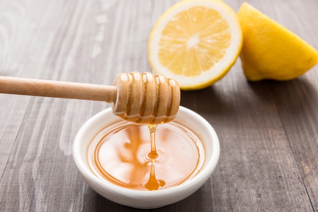 Tazón de dulce miel y limones en la mesa de madera