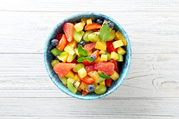 Tazón de ensalada de frutas frescas en la mesa de madera