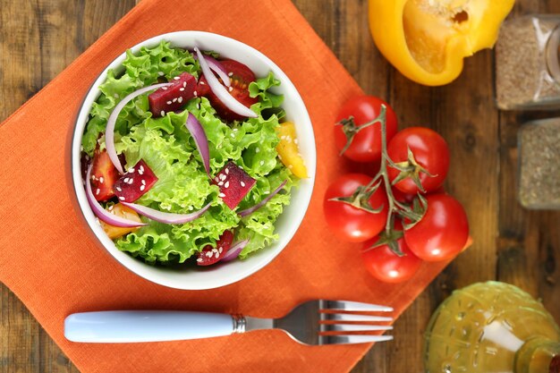 Foto tazón de ensalada verde fresca en la mesa con servilleta closeup