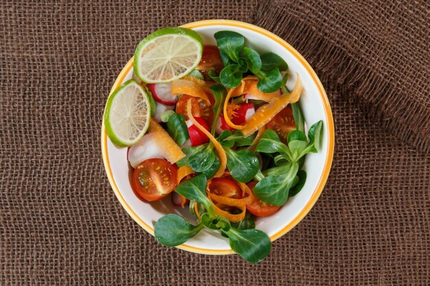 Tazón de ensalada de verduras frescas en mantel de yute