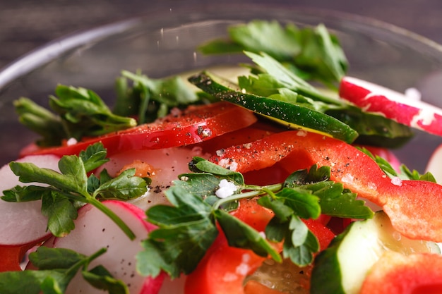 Tazón de ensalada con verduras y verduras en la mesa de madera