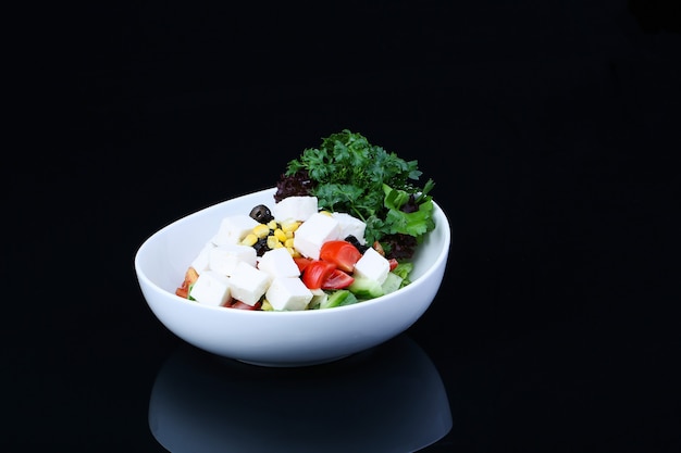 Foto tazón de fuente de ensalada de queso blanco con maíz y tomate y pimiento verde