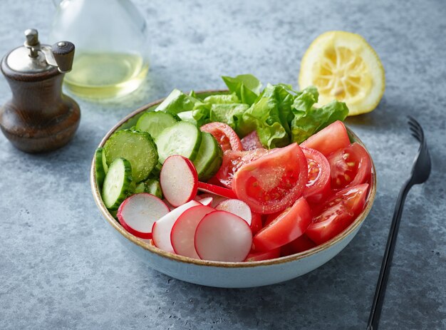 Tazón de fuente de ensalada de verduras frescas en la mesa de la cocina