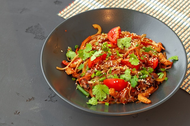 Tazón de fuente de fideos wok con verduras sobre fondo negro cerrar