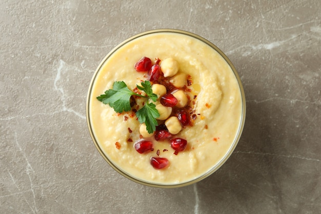 Tazón de fuente de hummus fresco con ingredientes en gris