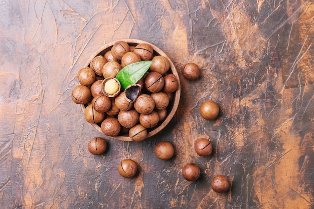 Tazón de fuente de nueces de macadamia sobre una mesa de hormigón. Vista superior.