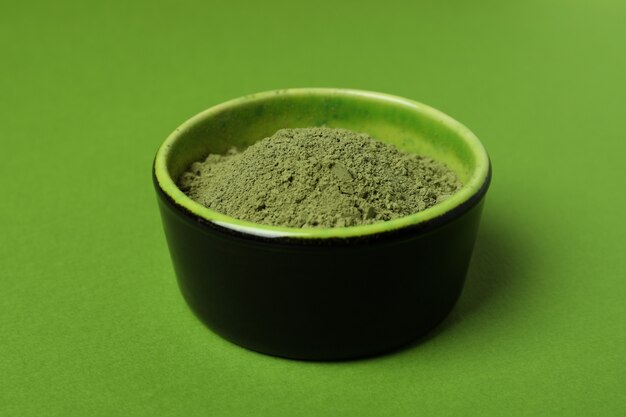 Tazón de fuente de polvo de matcha sobre fondo verde