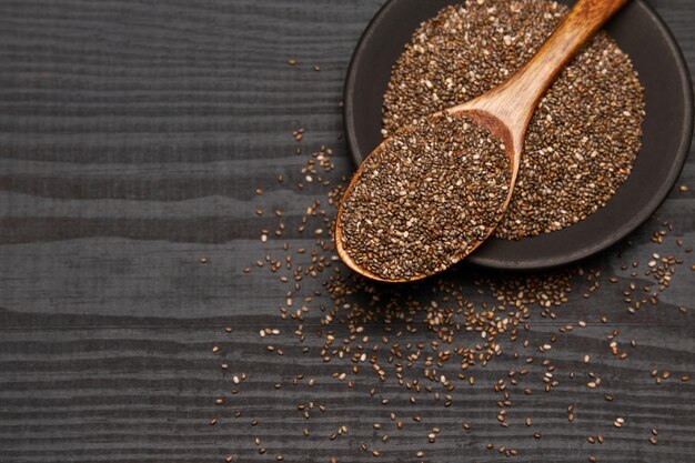 Tazón de fuente de semillas de chia naturales orgánicos closeup sobre fondo de madera o mesa