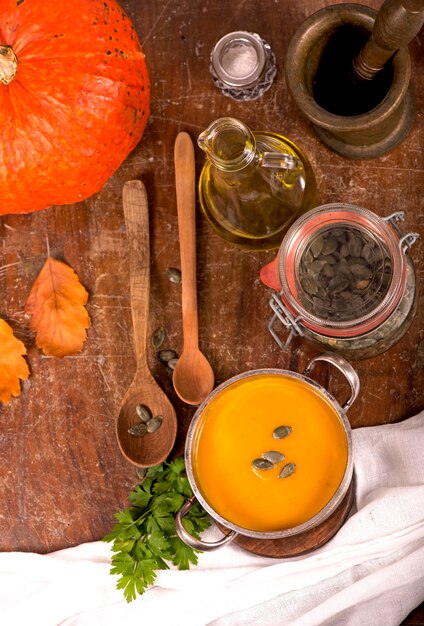 Tazón de fuente de sopa de calabaza sobre fondo de madera rústica.