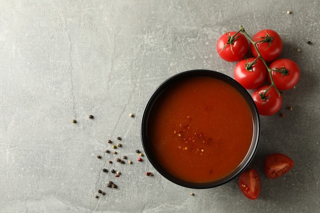 Tazón de fuente de sopa de tomate sabroso en gris