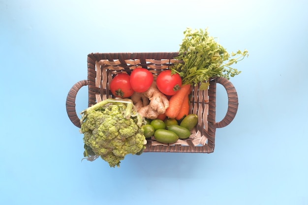 Tazón de fuente de verduras frescas sobre fondo azul de arriba hacia abajo