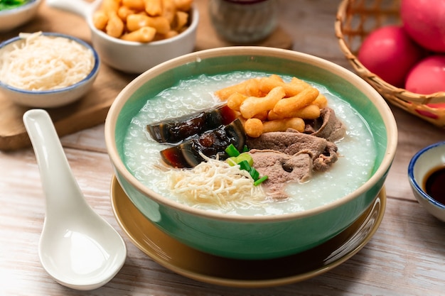 Tazón de gachas de arroz con huevo del siglo y un palito de masa frita crsipy llamado Patongo Thai mañanas aperitivo