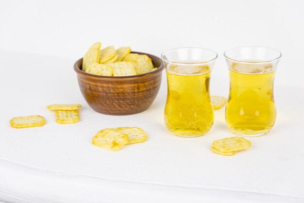 Un tazón de galletas saladas y dos vasos de cerveza.