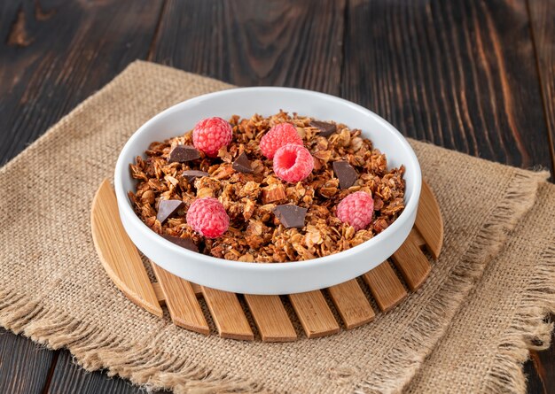 Tazón de granola casera con frambuesas frescas