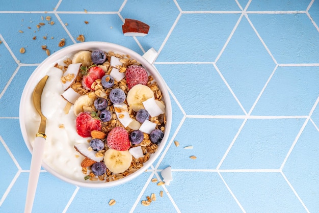 Un tazón de granola de yogur para el desayuno con frutas y bayas