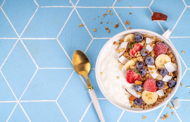 Un tazón de granola de yogur para el desayuno con frutas y bayas