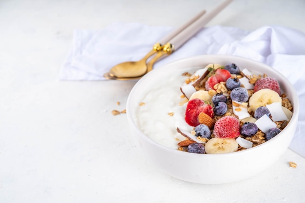 Un tazón de granola de yogur para el desayuno con frutas y bayas