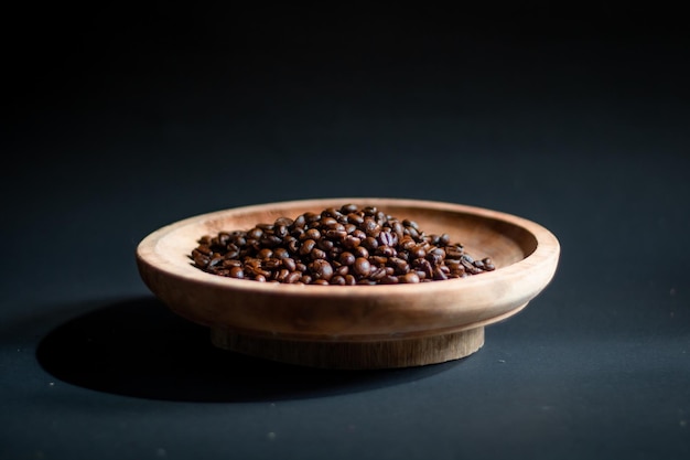 Un tazón de granos de café sobre un fondo oscuro