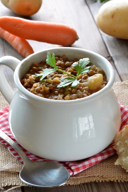 Tazón de guiso de lentejas con patatas y zanahorias