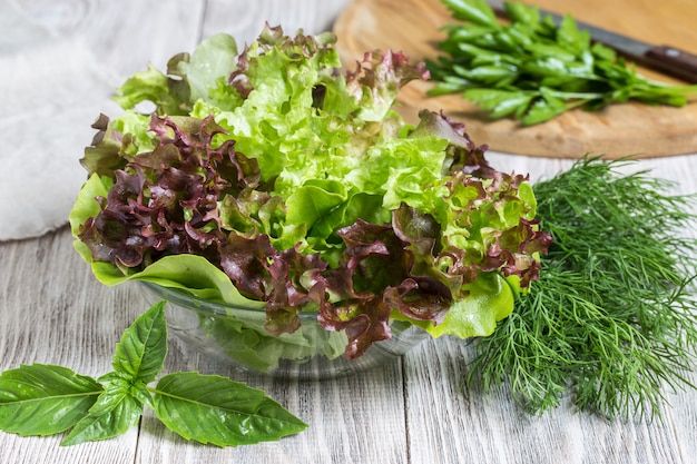 Tazón de hojas de lechuga en mesa de madera