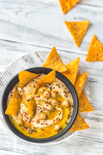 Foto tazón de hummus con tortilla chips