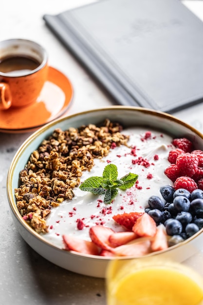 Un tazón lleno de bayas yogur y cereales concepto de desayuno saludable