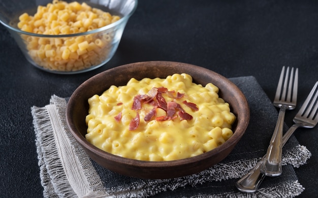 Tazón de macarrones con queso con rodajas de tocino frito