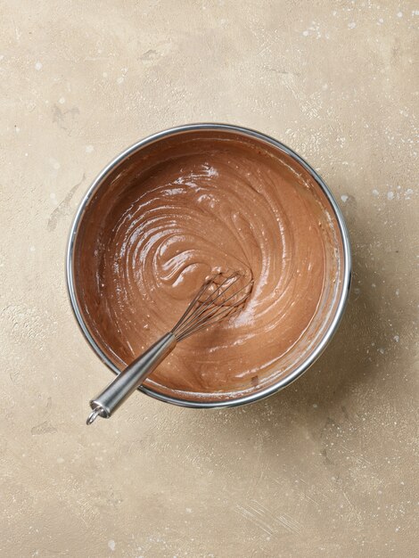 Tazón de masa de pastel de chocolate en la mesa de la cocina, vista superior