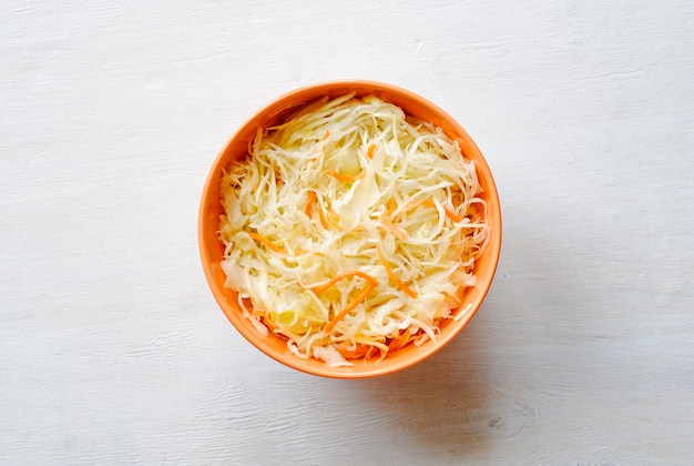 Tazón de naranja de verduras ralladas con repollo desde arriba