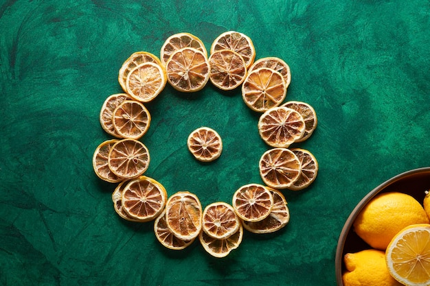 Un tazón de naranjas secas con un tazón de limones en el medio.