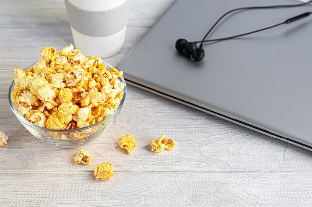 tazón con palomitas de maíz, gafas 3D y computadora portátil