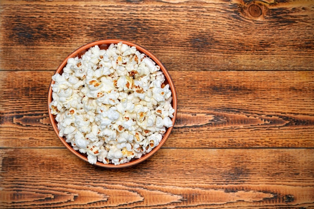 Tazón con palomitas de maíz sobre fondo de madera espacio de copia plano