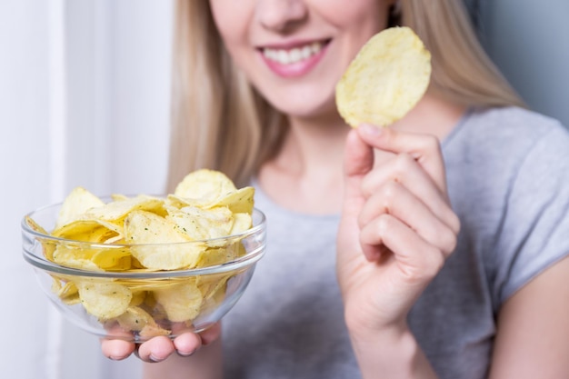 Tazón con papas fritas en manos femeninas