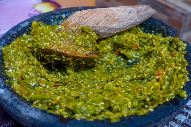 Foto un tazón de pasta de curry verde con una cuchara de madera.
