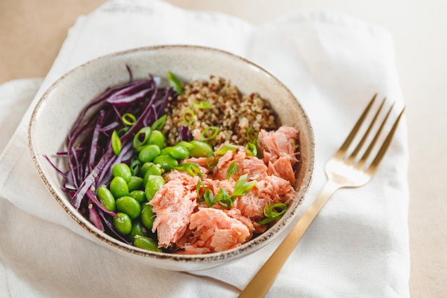 Tazón de poke con cuscús, frijol de salmón al horno y repollo Concepto de alimentación saludable